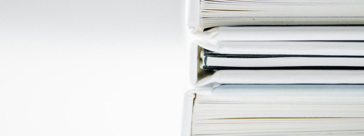 stack of binders with information on the most important real estate farming materials